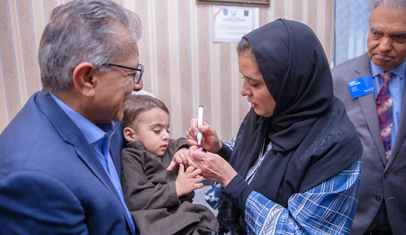 Regional director vaccinating Pakistani child against polio