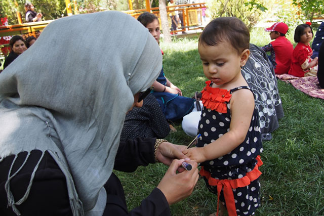 Credit: WHO Afghanistan/S.Ramo 1) Introducing a new a revisit strategy More children are reached during vaccination campaigns due to a modified and expanded revisit strategy. In line with the new strategy, vaccination teams revisit households where one or more children were missed from vaccination during the first team visit during the campaign week. Vaccination campaigns run from Mondays to Wednesdays, with a re-visit day on Friday when vaccinators go to households and public places like parks and markets to find children who have not yet been vaccinated. In this photo, Zahra marks the pinky finger of a child after vaccinating her during a picnic in a women’s garden in Kabul on a Friday re-visit.