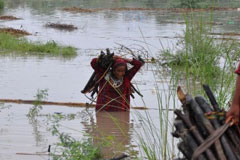 People carry their belongings through the flood water in Badin, Sindh, in 2011