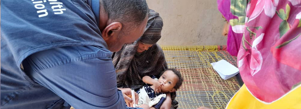 A health worker checks if a child's pinkie finger has been marked during a polio vaccination campaign, conducted in April 2024 in the Red Sea State, Sudan