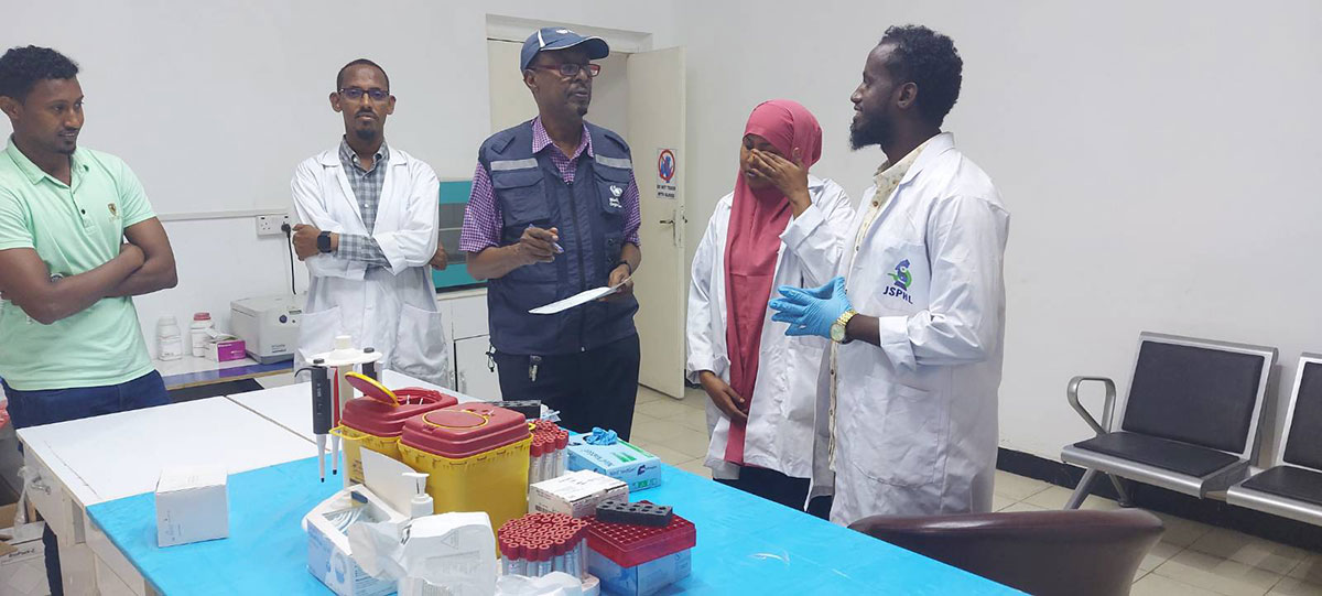 A WHO team member and Jubaland public health laboratory technicians discuss how to increase the testing capacity of IDSR priority conditions in Kismayo district, Jubaland state, Somalia. Photo credit: WHO/ WHO Somalia