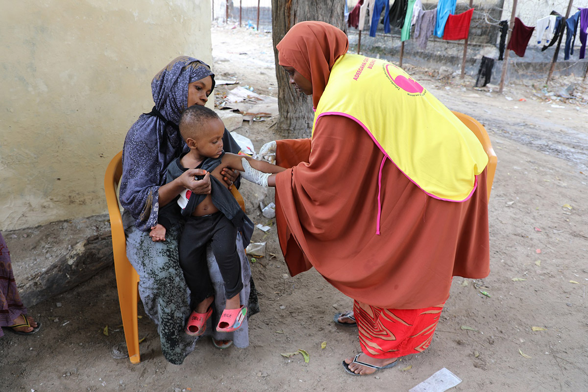 Hani administering a vaccine injection to a child at Weberi in Mogadishu