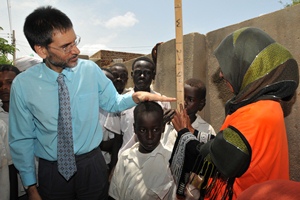 Dr Anshu Banerjee measuring the height of a student in Gezira state during the launch of schistosomiasis campaign