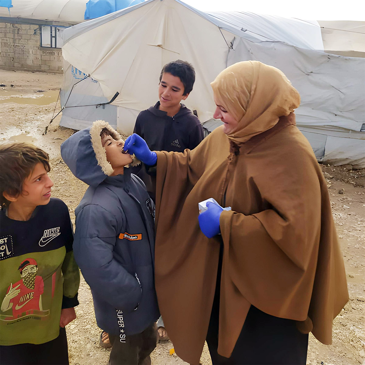 A volunteer gives the cholera vaccine to a child at Al-Hol camp, helping protect the community from the outbreak. Photo: WHO.