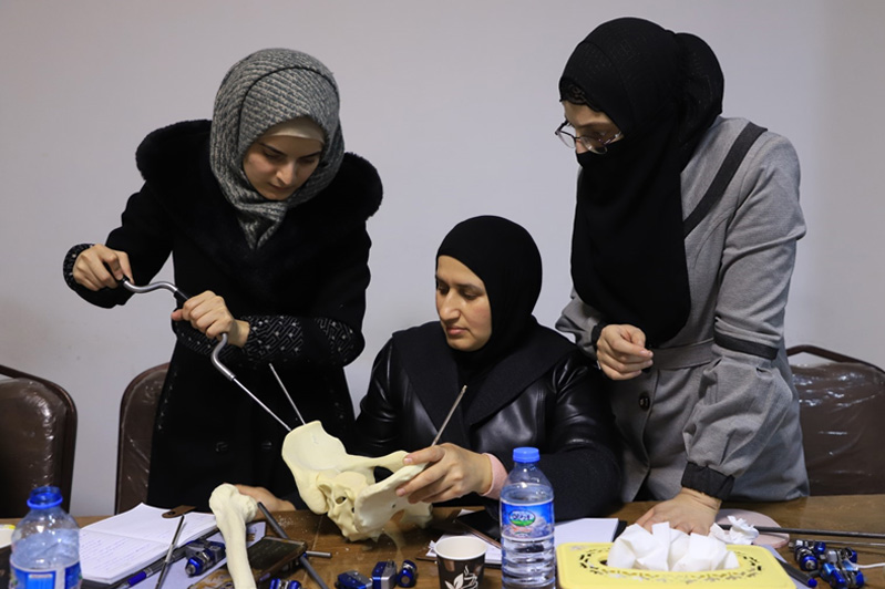 Participants at the HEST collaborate on a practical exercise, using anatomical models to refine critical surgical techniques for conflict and emergency settings. Photo: WHO