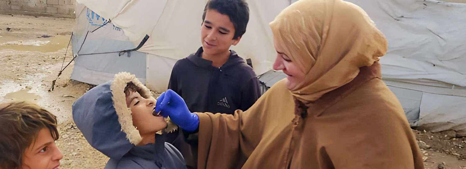 Walaa Mohammed, a resident of Al-Hol camp and outreach volunteer, speaks with her neighbours to address concerns and build trust in the cholera vaccination campaign