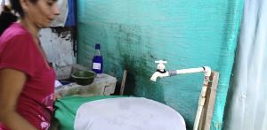 A woman covers an open container of water to prevent mosquitoes breeding and spreading Zika virus disease